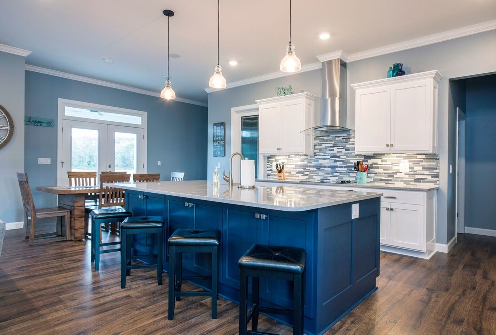 Mid-sized transitional single-wall dark wood floor and brown floor enclosed kitchen photo in Columbus with a farmhouse sink, shaker cabinets, white cabinets, granite countertops, multicolored backsplash, matchstick tile backsplash, stainless steel appliances, an island and gray countertops