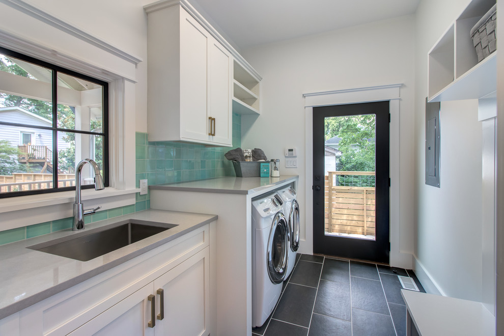 This is an example of a mid-sized country dedicated laundry room in Raleigh with an undermount sink, shaker cabinets, white cabinets, white walls, a side-by-side washer and dryer, black floor and grey benchtop.