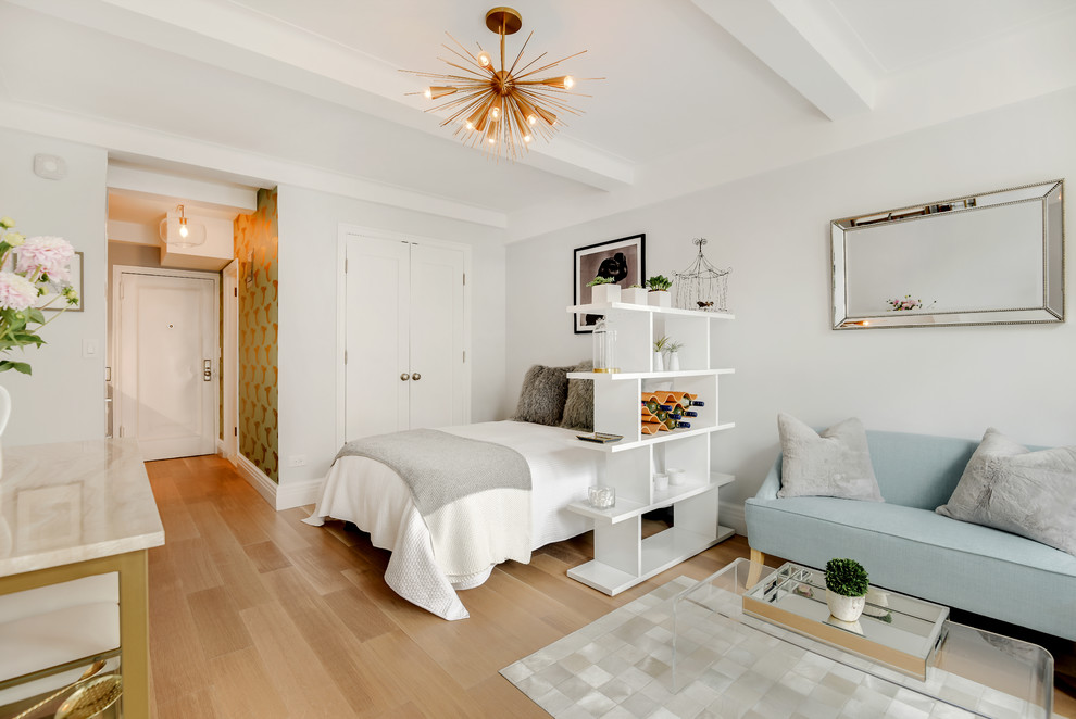This is an example of a small contemporary bedroom in New York with grey walls, medium hardwood floors and brown floor.