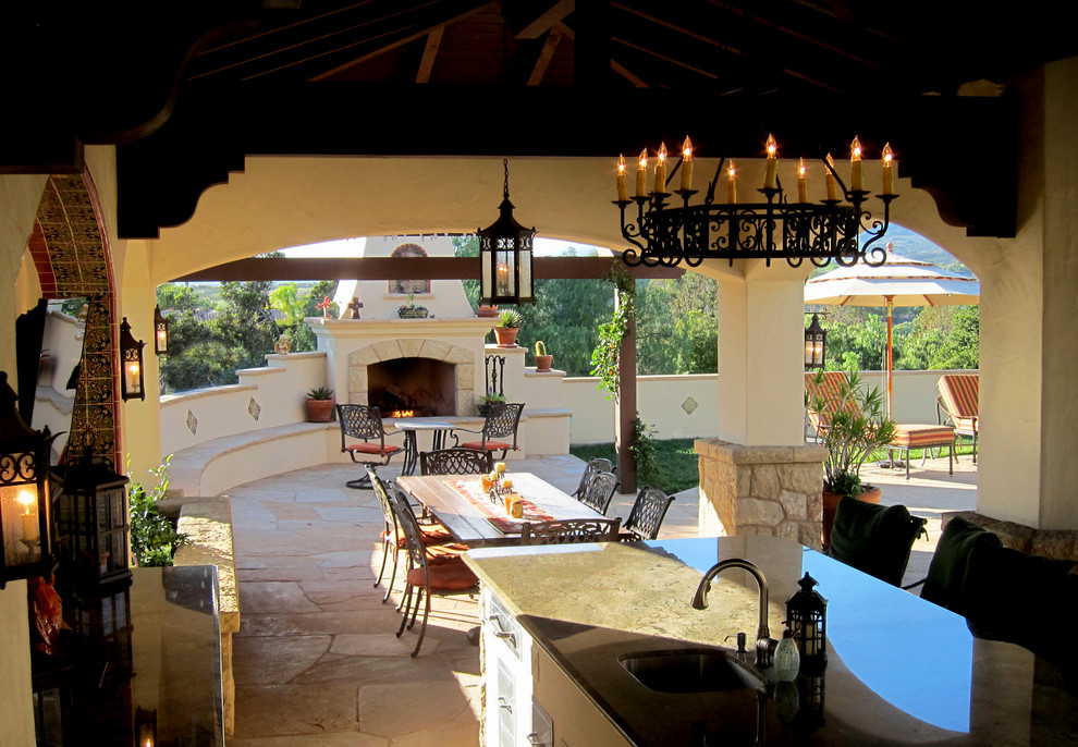 This is an example of a mid-sized mediterranean backyard patio in Santa Barbara with natural stone pavers and a gazebo/cabana.