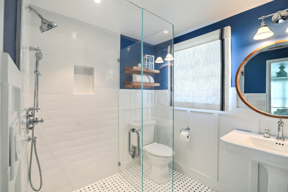 Photo of a medium sized beach style family bathroom in Other with white cabinets, a built-in shower, blue walls, a pedestal sink, grey floors, a hinged door, white worktops, a single sink and a freestanding vanity unit.