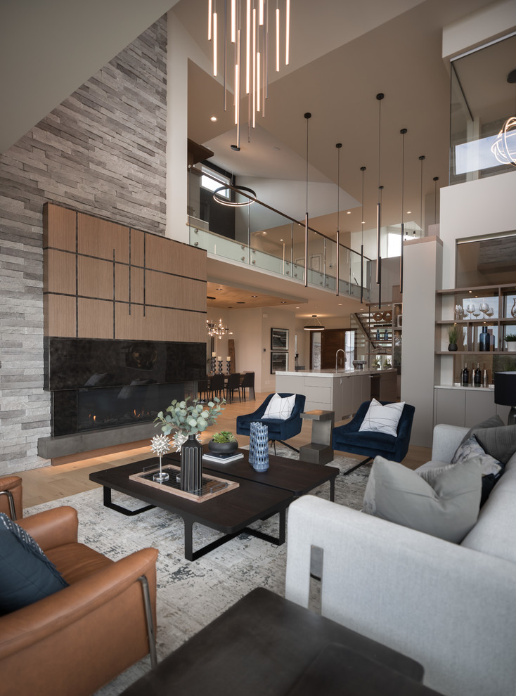 Trendy open concept light wood floor and beige floor living room photo in Calgary with a ribbon fireplace and a stone fireplace