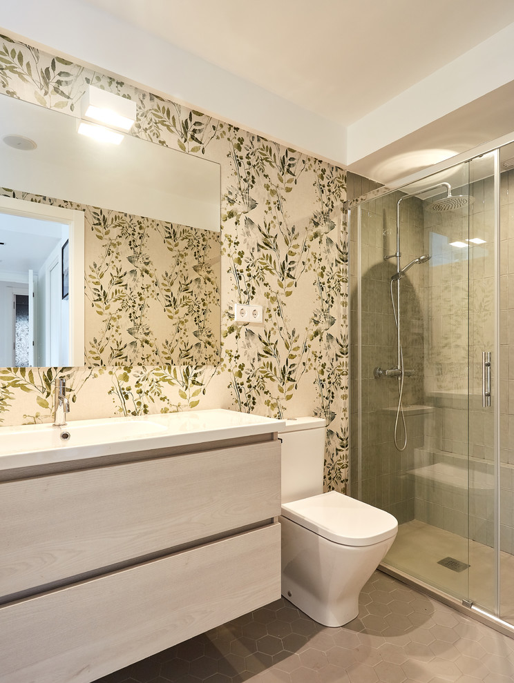 Photo of a mid-sized contemporary master bathroom in Madrid with flat-panel cabinets, light wood cabinets, a corner shower, grey floor, a sliding shower screen, white benchtops, green tile, ceramic tile, green walls, ceramic floors and a wall-mount sink.
