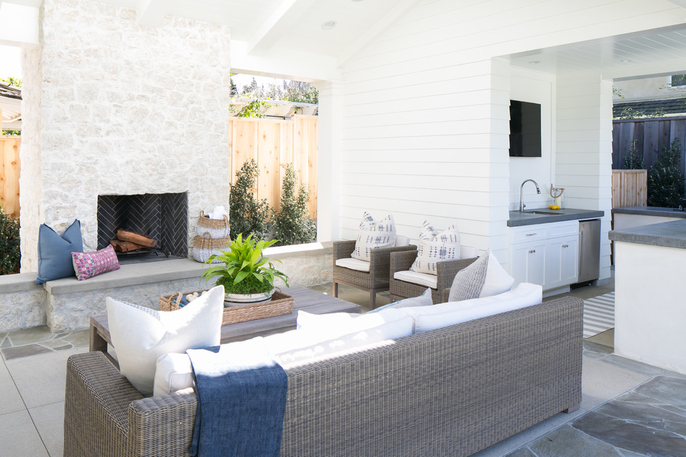 Patio - large coastal backyard concrete paver patio idea in Orange County with a fire pit and a roof extension