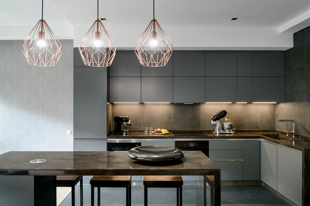 Inspiration for a mid-sized contemporary l-shaped open plan kitchen in Other with grey cabinets, solid surface benchtops, porcelain splashback, porcelain floors, grey floor, grey benchtop, an undermount sink, flat-panel cabinets, grey splashback, black appliances and with island.