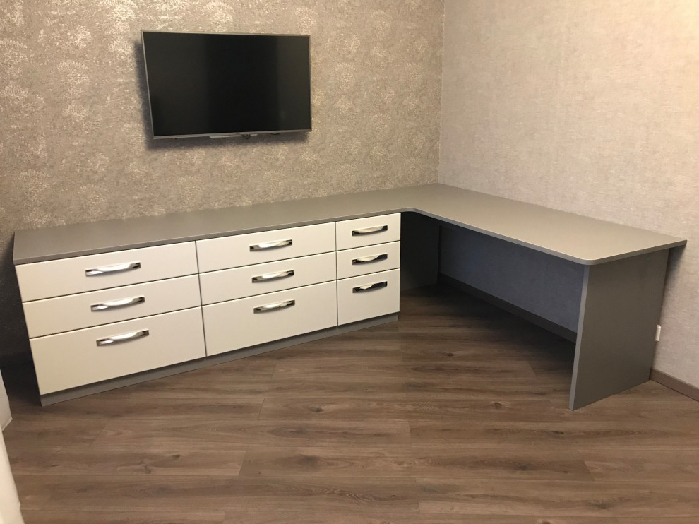 Diseño de despacho actual de tamaño medio con paredes grises, escritorio independiente, suelo marrón y papel pintado