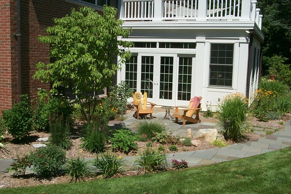 Inspiration for a traditional backyard patio in Grand Rapids with natural stone pavers.