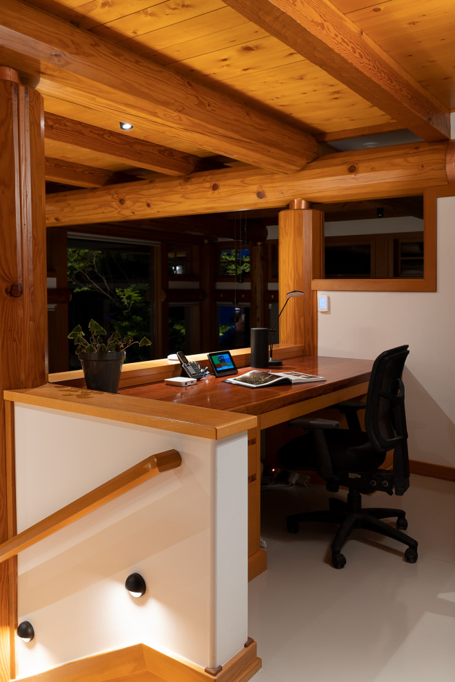 На фото: кабинет среднего размера в современном стиле с бежевыми стенами, бетонным полом, встроенным рабочим столом, серым полом, балками на потолке и деревянными стенами с
