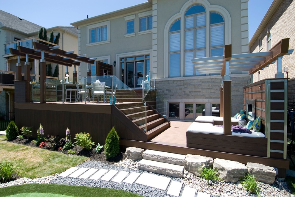 This is an example of a large contemporary backyard deck in Toronto with an outdoor kitchen and a pergola.