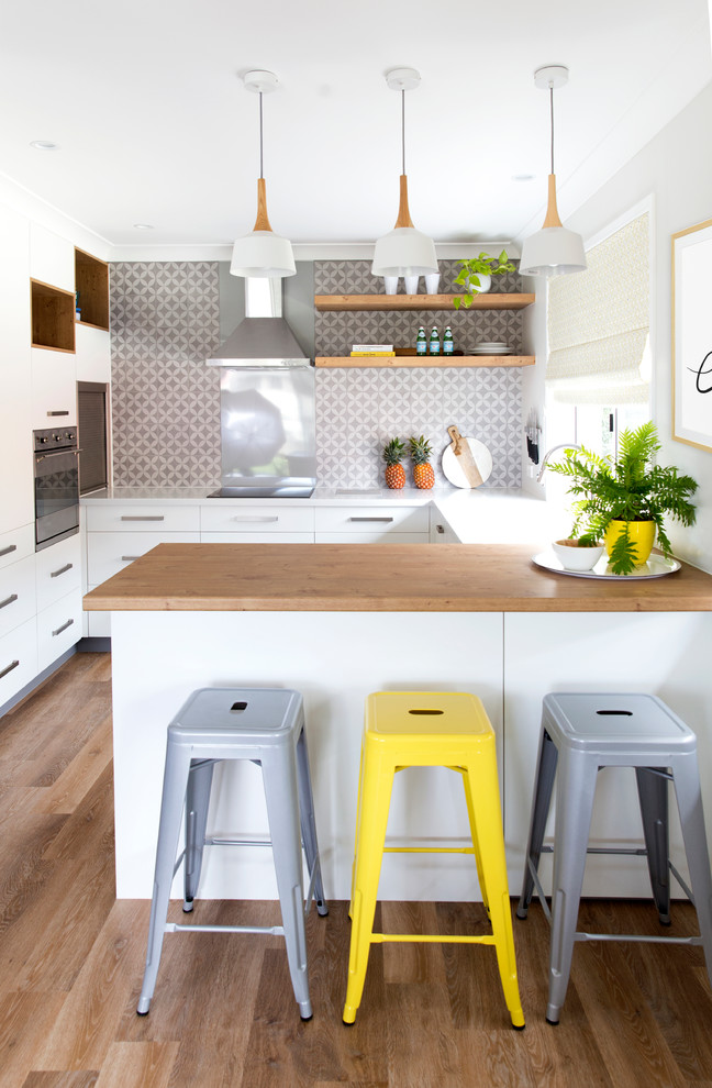 Design ideas for a small scandinavian u-shaped eat-in kitchen in Gold Coast - Tweed with an integrated sink, flat-panel cabinets, white cabinets, quartz benchtops, grey splashback, ceramic splashback, stainless steel appliances, vinyl floors and a peninsula.