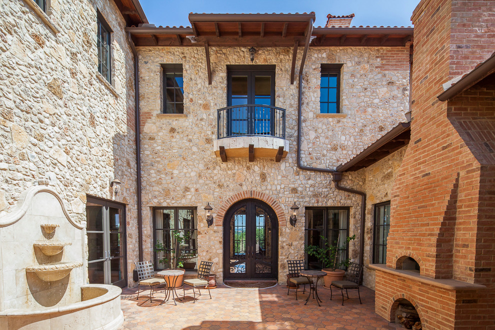 Inspiration for a large mediterranean courtyard patio in Austin with tile and no cover.