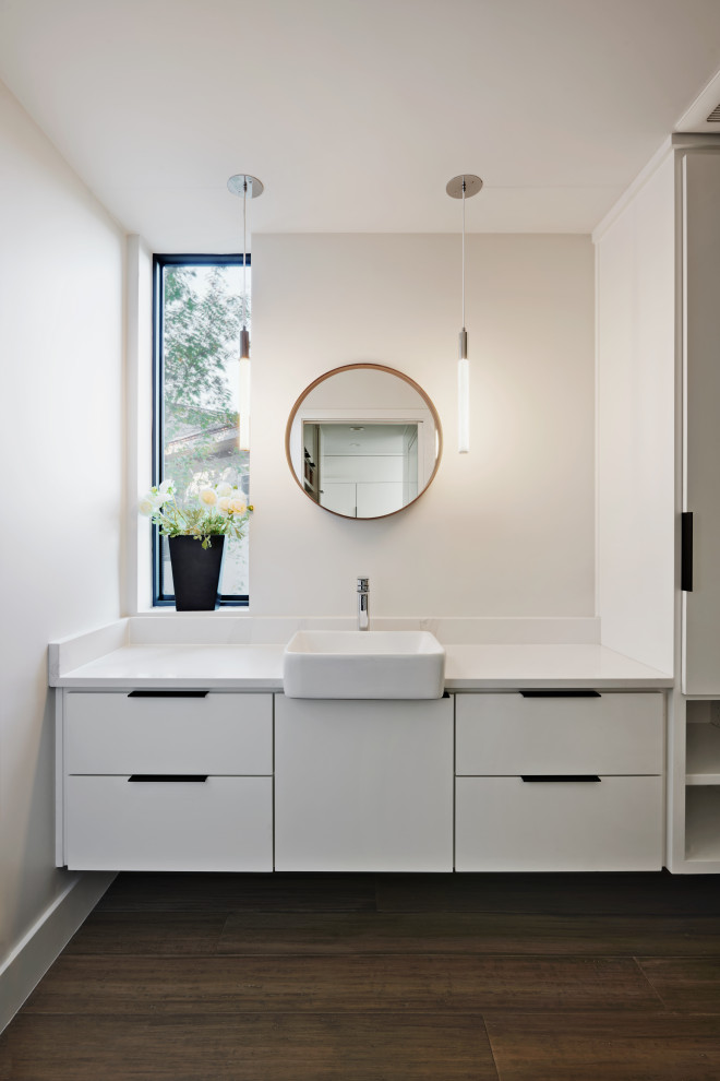 Inspiration for a mid-sized modern powder room in Austin with flat-panel cabinets, white cabinets, a wall-mount toilet, grey walls, bamboo floors, a vessel sink, engineered quartz benchtops, grey floor, white benchtops and a floating vanity.