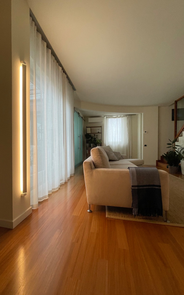 Esempio di un soggiorno minimal con pareti beige, pavimento in legno verniciato, pavimento marrone e con abbinamento di mobili antichi e moderni