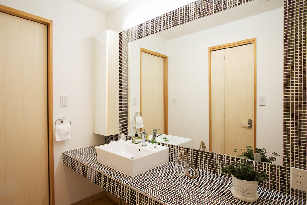 This is an example of a scandinavian powder room in Kyoto with white walls and a vessel sink.