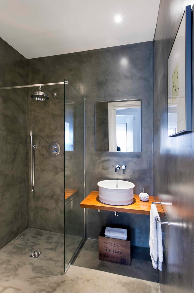 Inspiration for a mid-sized contemporary 3/4 bathroom in Barcelona with a curbless shower, grey walls, concrete floors, a vessel sink, wood benchtops and an open shower.