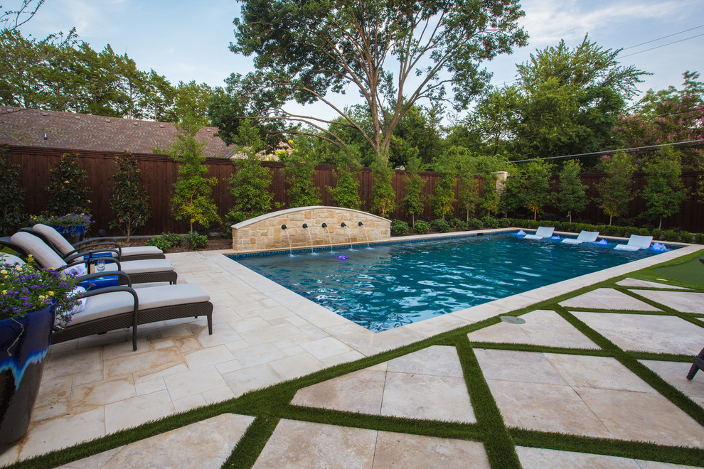Example of a mid-sized tuscan backyard stone and rectangular lap pool fountain design in Dallas