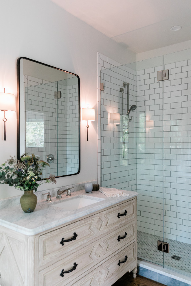 Photo of a mid-sized transitional master bathroom in Other with light wood cabinets, white walls, an undermount sink, marble benchtops, brown floor, a hinged shower door, white benchtops, a single vanity, a freestanding vanity, raised-panel cabinets, an alcove shower, white tile and dark hardwood floors.