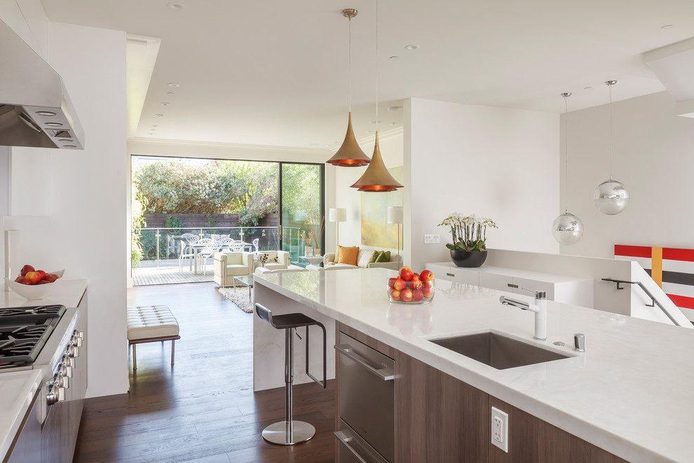 Photo of a large contemporary u-shaped open plan kitchen in San Francisco with an undermount sink, flat-panel cabinets, stainless steel appliances, with island, dark hardwood floors, white cabinets, quartz benchtops, white splashback, stone slab splashback and brown floor.