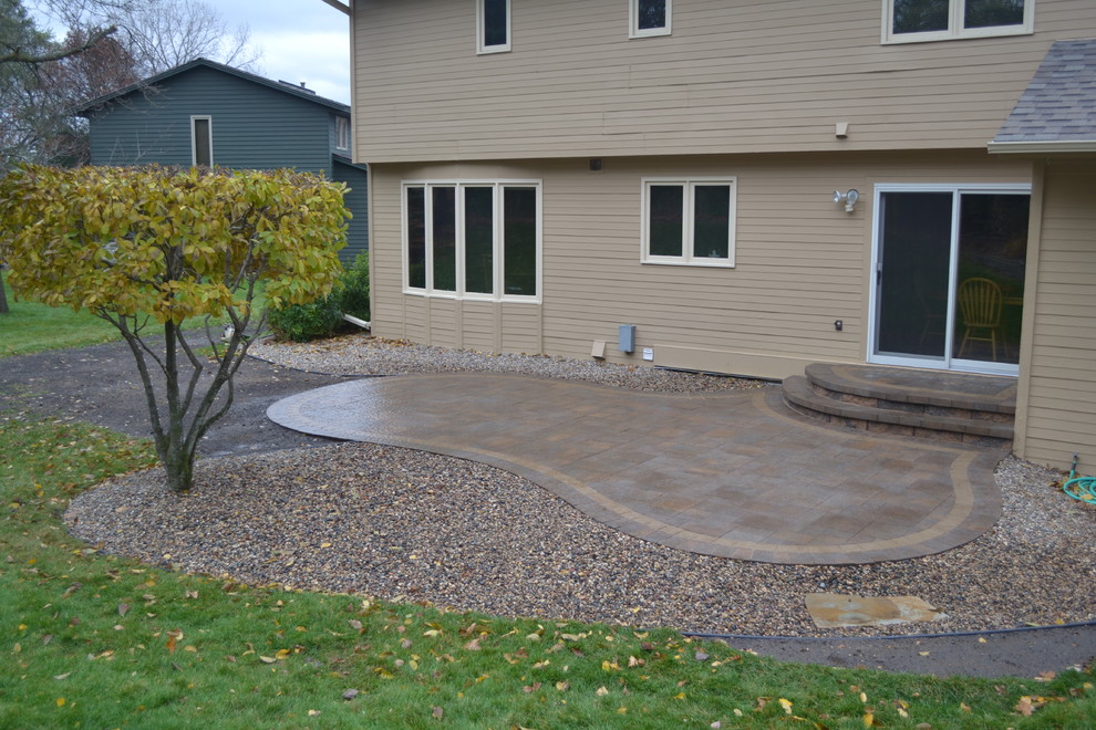 This is an example of a mid-sized contemporary backyard patio in Minneapolis with brick pavers.