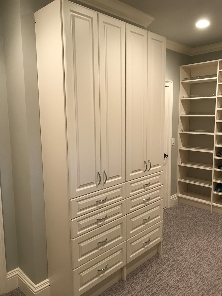 Photo of a large traditional gender-neutral walk-in wardrobe in Huntington with raised-panel cabinets, white cabinets, carpet and grey floor.