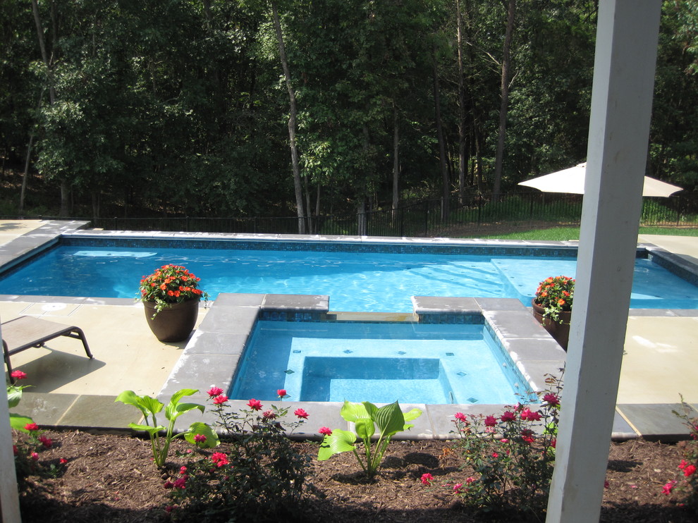 Photo of a mid-sized traditional backyard rectangular natural pool in DC Metro with concrete slab and a hot tub.