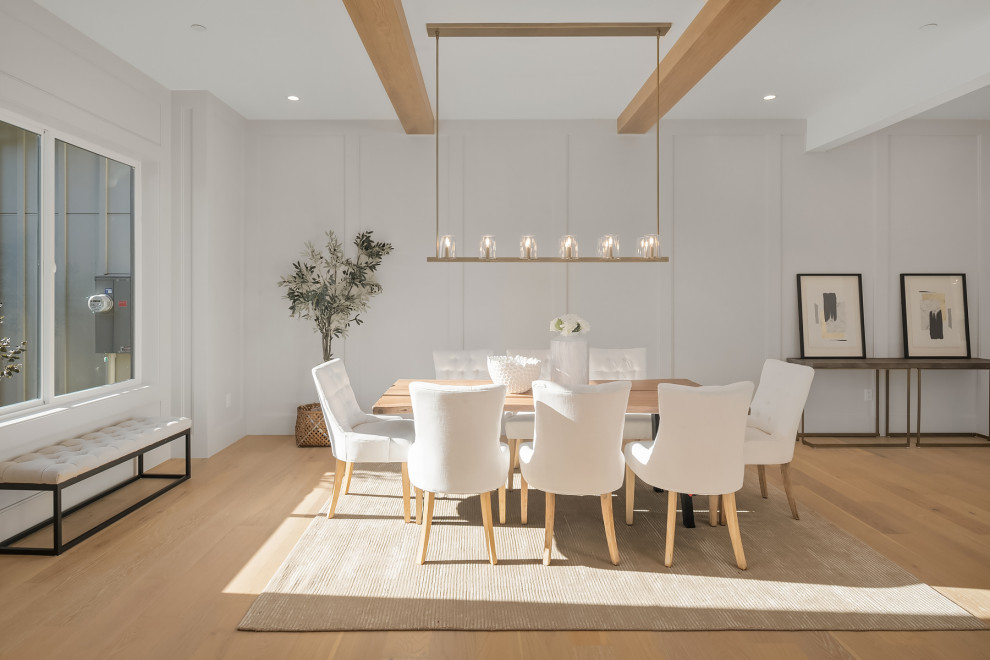 Photo of a large contemporary open plan dining in Seattle with white walls, light hardwood floors, exposed beam and panelled walls.