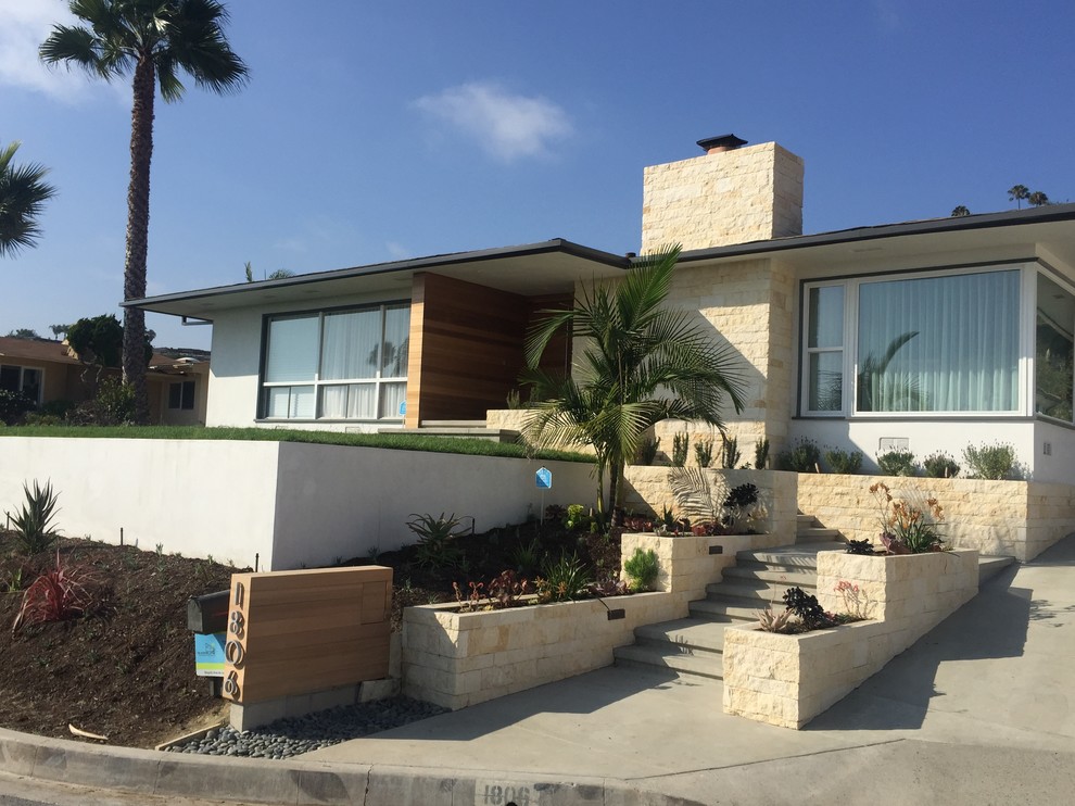Design ideas for a large midcentury one-storey beige exterior in Orange County with stone veneer and a flat roof.