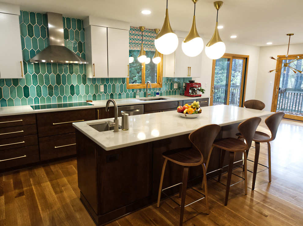 This is an example of a mid-sized midcentury u-shaped eat-in kitchen in Detroit with an undermount sink, flat-panel cabinets, white cabinets, quartz benchtops, green splashback, ceramic splashback, stainless steel appliances, medium hardwood floors, with island, brown floor and white benchtop.