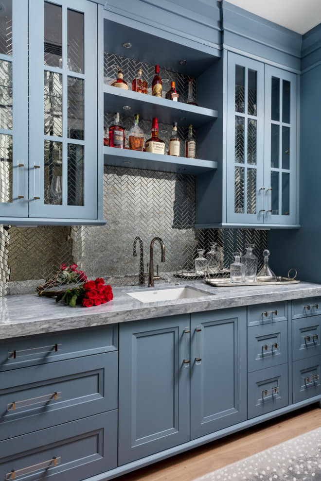 Design ideas for an expansive traditional galley wet bar in Miami with a built-in sink, recessed-panel cabinets, blue cabinets, marble worktops, multi-coloured splashback, mosaic tiled splashback, medium hardwood flooring, brown floors and blue worktops.