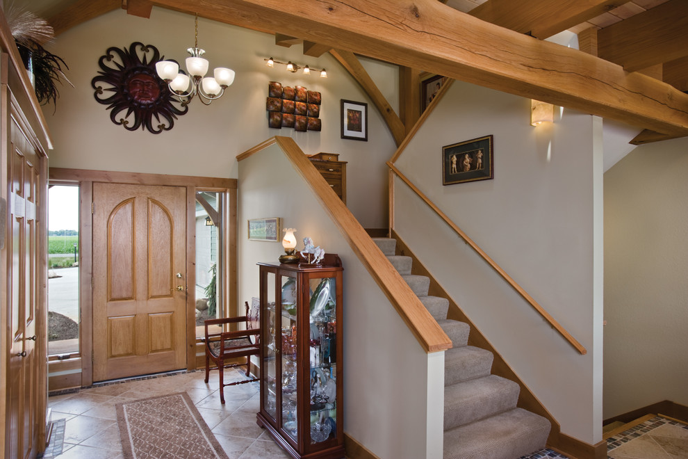 This is an example of a traditional entryway in Other with white walls, ceramic floors, a single front door and a medium wood front door.