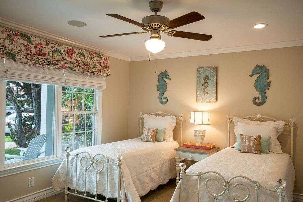 This is an example of a mid-sized beach style guest bedroom in San Diego with beige walls, carpet and no fireplace.