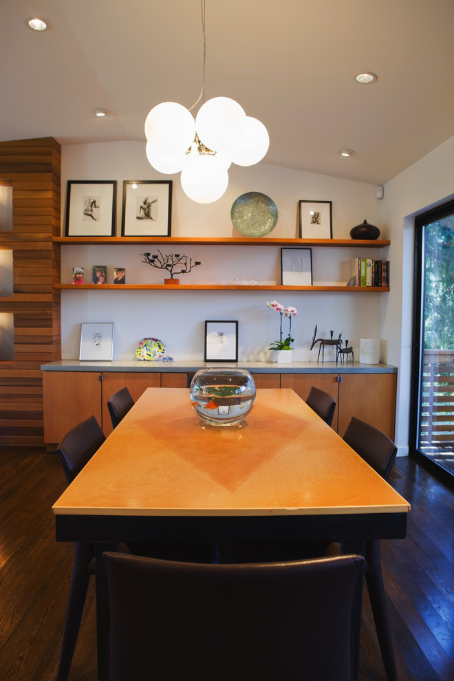 Modern dining room in Portland with white walls and dark hardwood floors.