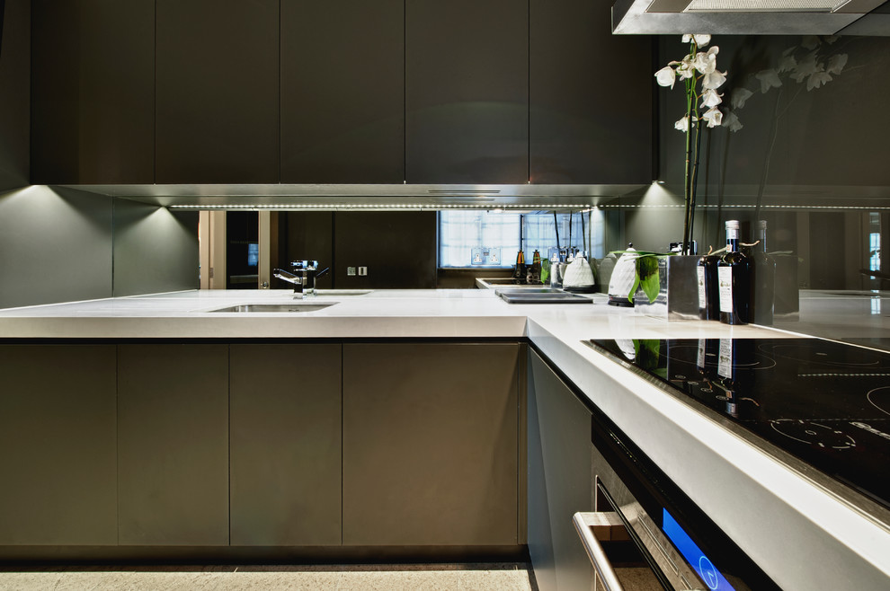 This is an example of a mid-sized contemporary l-shaped kitchen in Surrey with quartz benchtops.