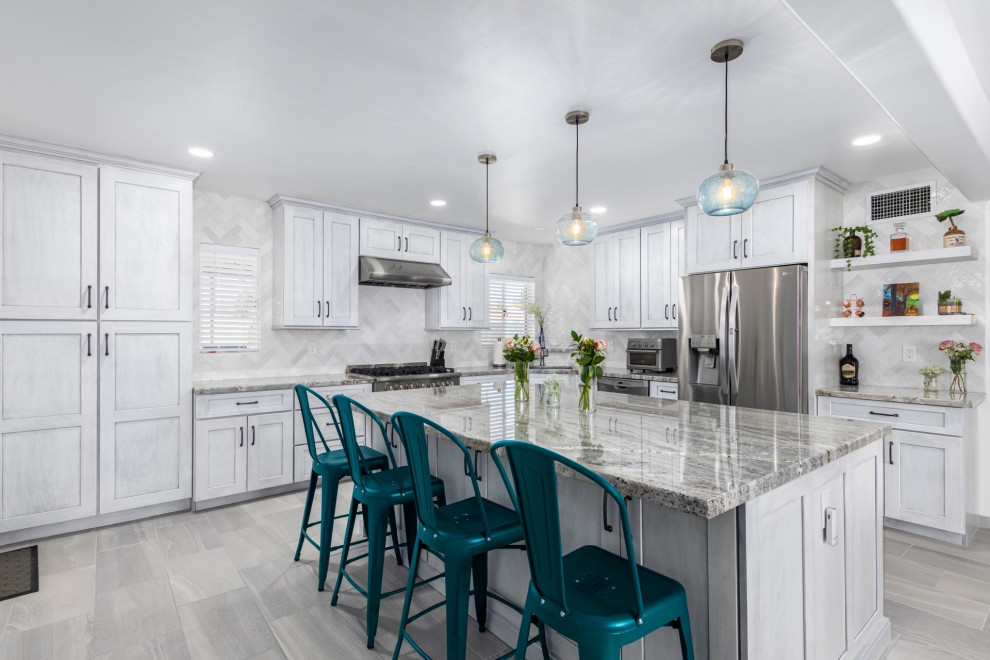 Kitchen - transitional l-shaped kitchen idea in Phoenix with a single-bowl sink, shaker cabinets, white cabinets, granite countertops, white backsplash and stainless steel appliances