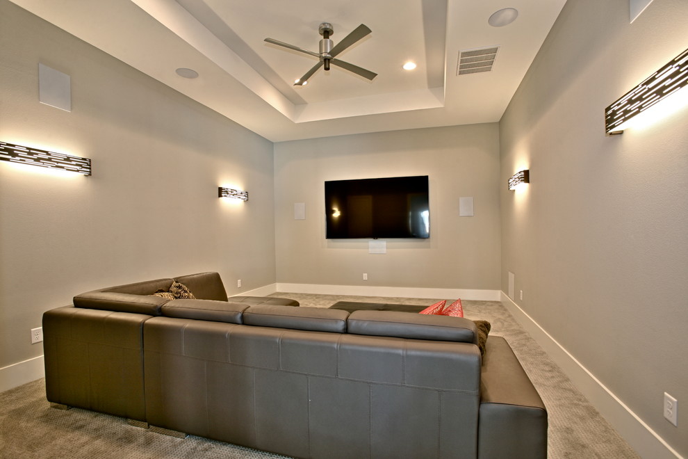 Mid-sized contemporary enclosed home theatre in Dallas with carpet, a wall-mounted tv, beige floor and grey walls.