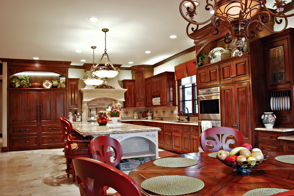 Large traditional eat-in kitchen in Kansas City with an undermount sink, raised-panel cabinets, medium wood cabinets, granite benchtops, beige splashback, stainless steel appliances, limestone floors and with island.