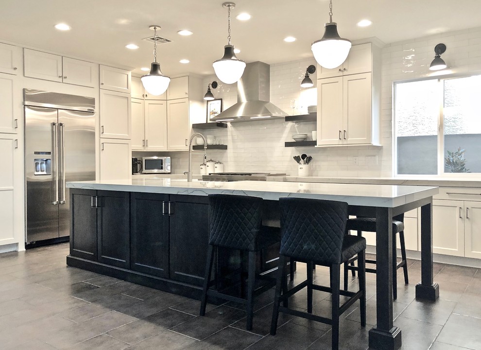 Mid-sized country l-shaped separate kitchen in Las Vegas with a farmhouse sink, shaker cabinets, white cabinets, marble benchtops, white splashback, subway tile splashback, stainless steel appliances, concrete floors, with island, grey floor and white benchtop.