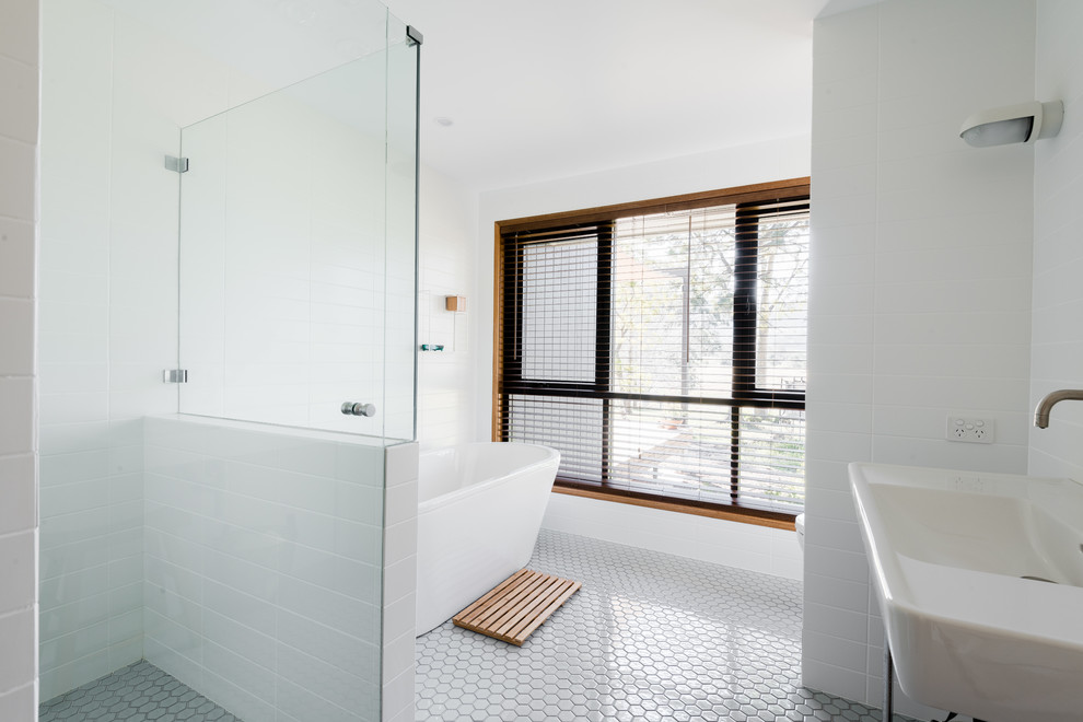 Large midcentury master bathroom in Other with a freestanding tub, a corner shower, a one-piece toilet, white tile, ceramic tile, white walls, mosaic tile floors, a wall-mount sink, grey floor and a hinged shower door.