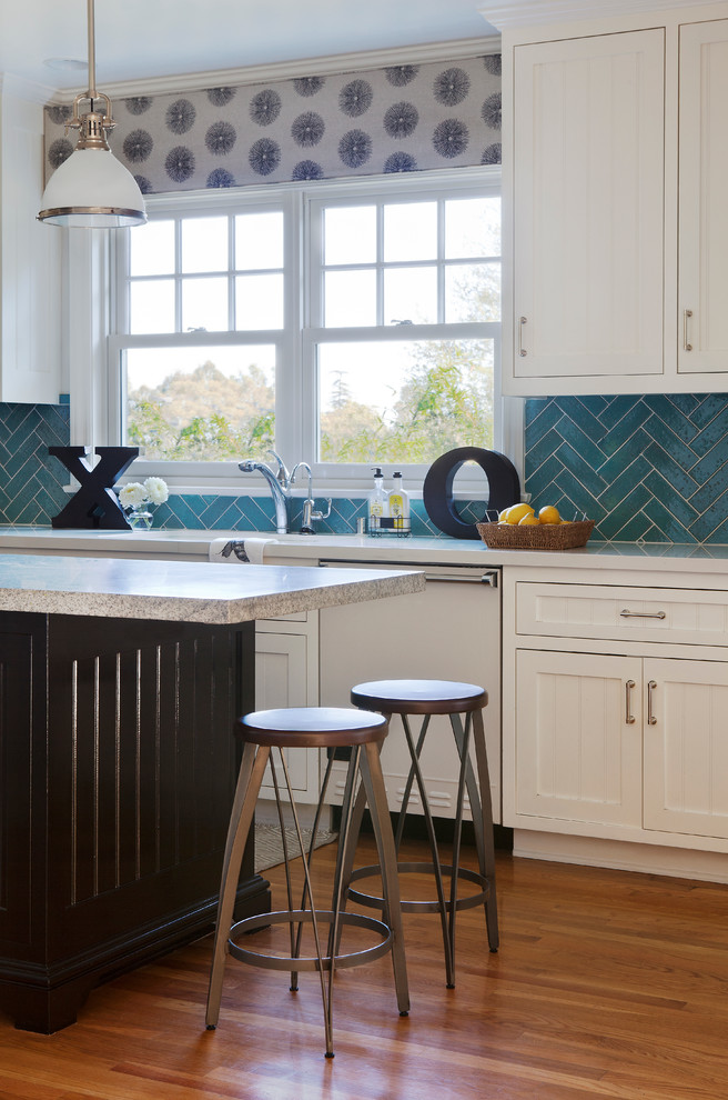 This is an example of a mid-sized traditional galley eat-in kitchen in Los Angeles with a drop-in sink, beaded inset cabinets, white cabinets, marble benchtops, blue splashback, cement tile splashback, white appliances, medium hardwood floors and with island.