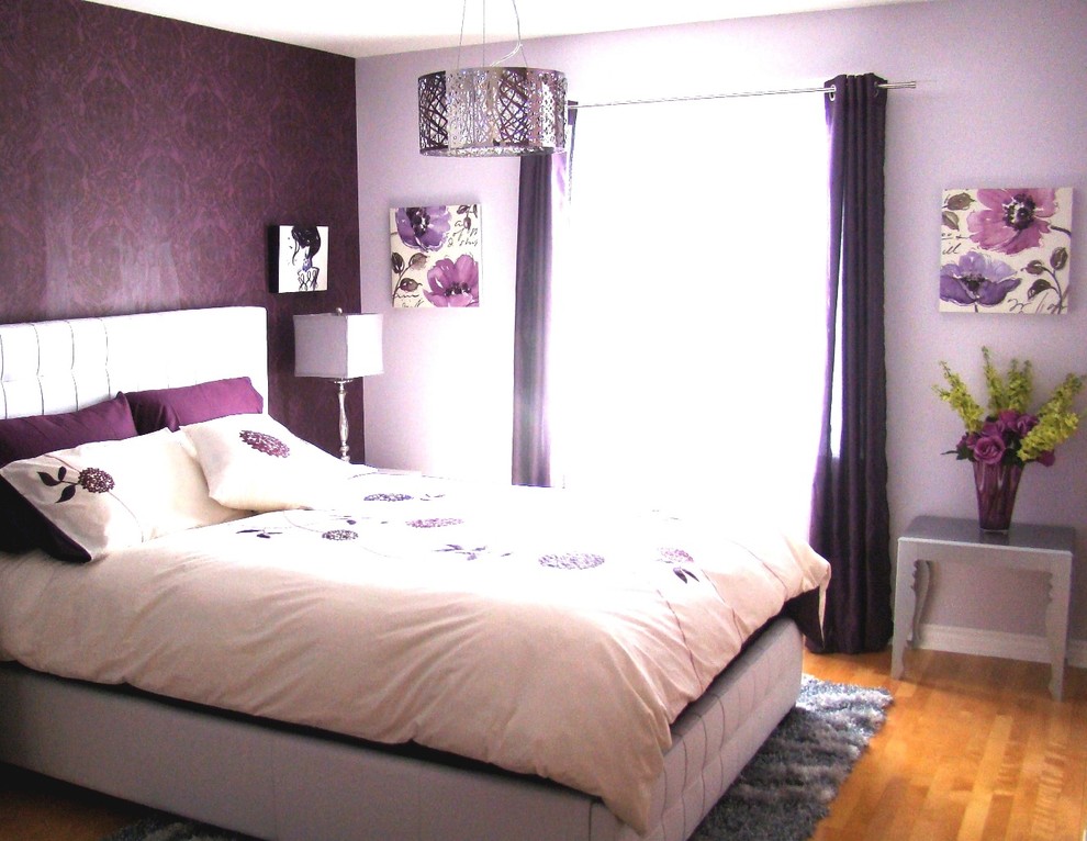 Design ideas for a mid-sized transitional bedroom in Montreal with wallpaper, purple walls, light hardwood floors and brown floor.