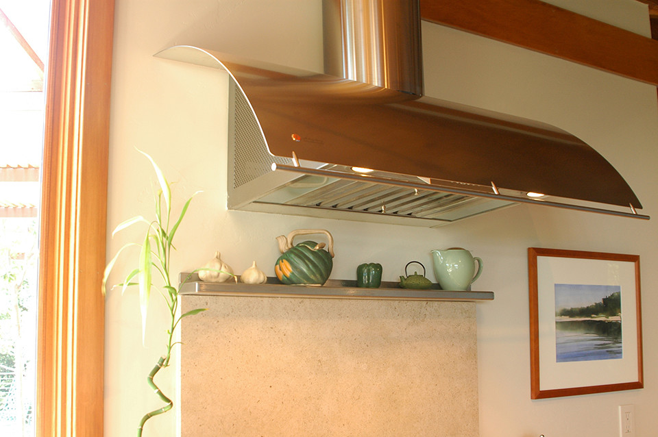 This is an example of a mid-sized eclectic u-shaped open plan kitchen in San Francisco with an undermount sink, flat-panel cabinets, medium wood cabinets, limestone benchtops, beige splashback, stone slab splashback, stainless steel appliances, ceramic floors and with island.