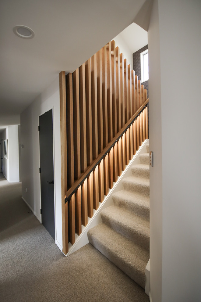 Стильный дизайн: прямая лестница среднего размера в современном стиле с ступенями с ковровым покрытием, деревянными перилами и обоями на стенах - последний тренд