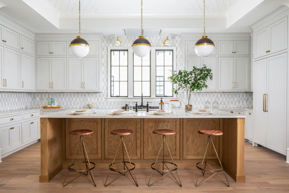 Example of a large transitional u-shaped medium tone wood floor and brown floor open concept kitchen design in Charlotte with a farmhouse sink, beaded inset cabinets, gray cabinets, quartz countertops, mosaic tile backsplash, paneled appliances, an island and white countertops