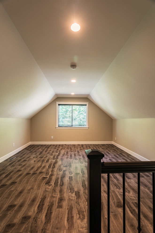 This is an example of a mid-sized traditional loft-style family room in Vancouver with a game room, beige walls, laminate floors, a wall-mounted tv and brown floor.
