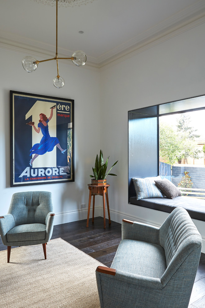 Photo of a mid-sized contemporary enclosed living room in Melbourne with a library, white walls, dark hardwood floors, a standard fireplace and a brick fireplace surround.