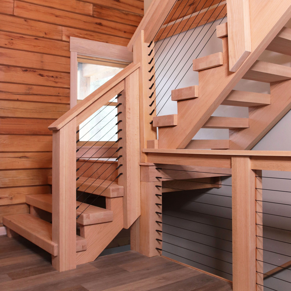 Photo of a mid-sized country wood l-shaped staircase in New York with open risers, cable railing and wood walls.