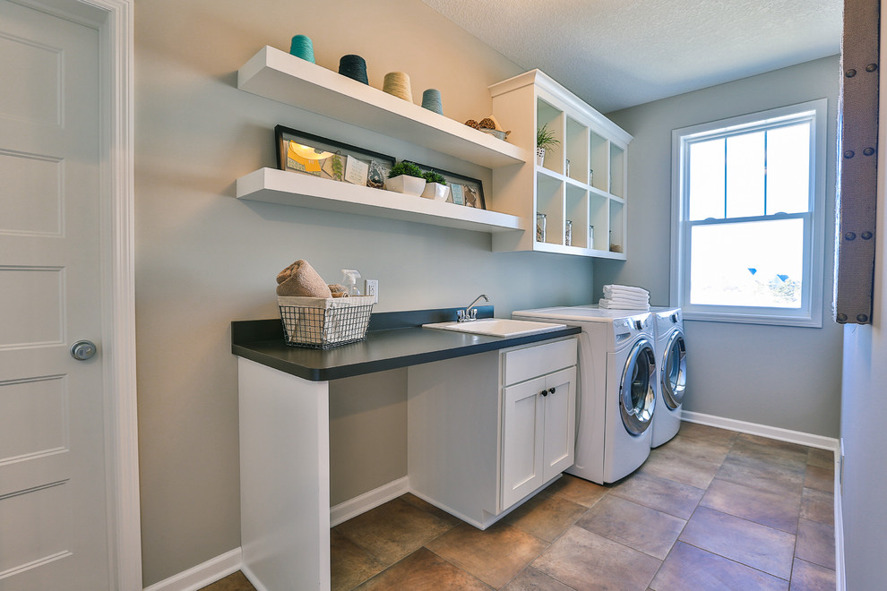 Inspiration for a mid-sized contemporary single-wall laundry room in Minneapolis with a drop-in sink, open cabinets, white cabinets, laminate benchtops, grey walls, ceramic floors and a side-by-side washer and dryer.