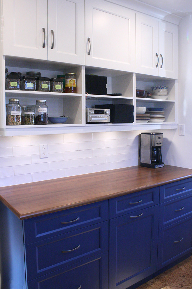This is an example of a transitional galley kitchen pantry in Toronto with shaker cabinets, white cabinets, laminate benchtops, ceramic splashback, stainless steel appliances and cork floors.