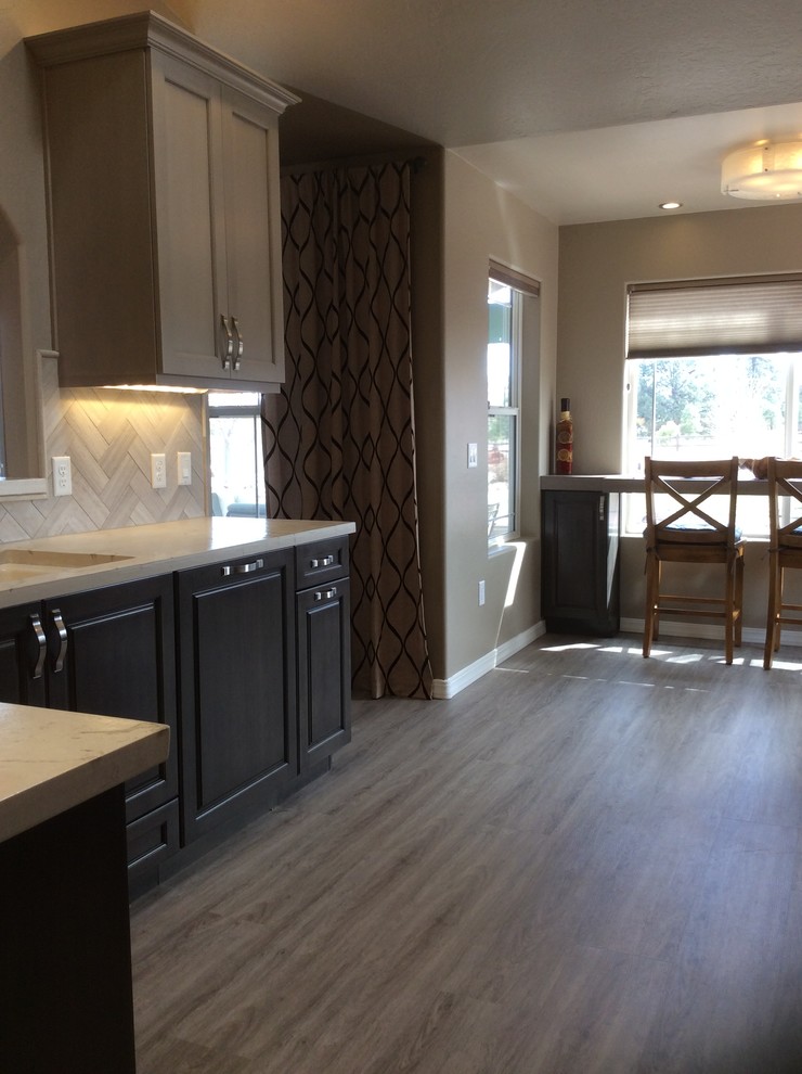Inspiration for a mid-sized transitional dark wood floor and brown floor eat-in kitchen remodel in Phoenix with a single-bowl sink, raised-panel cabinets, dark wood cabinets, onyx countertops, brown backsplash, ceramic backsplash, stainless steel appliances and an island