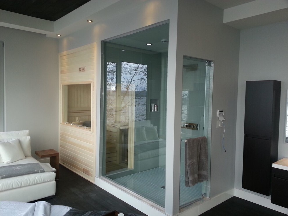 This is an example of a mid-sized modern bathroom in Montreal with an alcove shower, white tile, grey walls, dark hardwood floors, with a sauna, black floor and a hinged shower door.